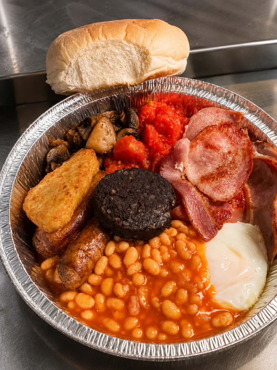 Full breakfast with sausage, bacon, black pudding, egg, mushrooms and beans