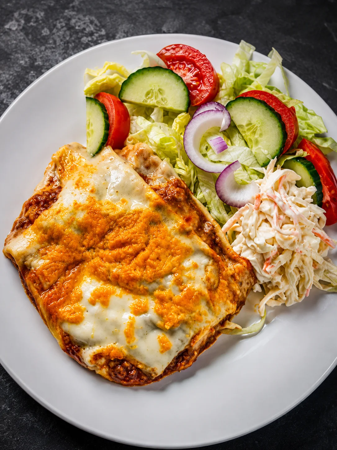 Cheesy baked dish served with salad and coleslaw