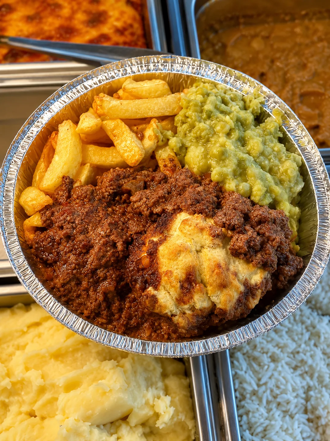 Hot plate with chips, mushy peas and a savoury meat dish