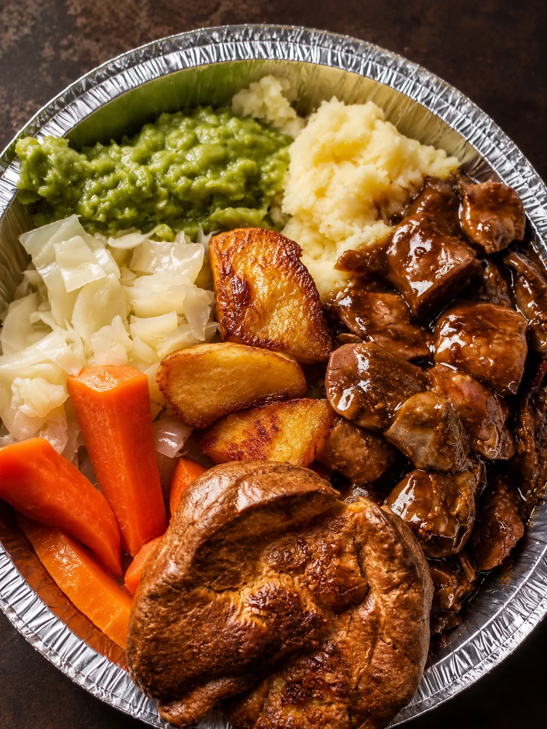 Roast dinner with chicken, potatoes, carrots, cabbage and peas