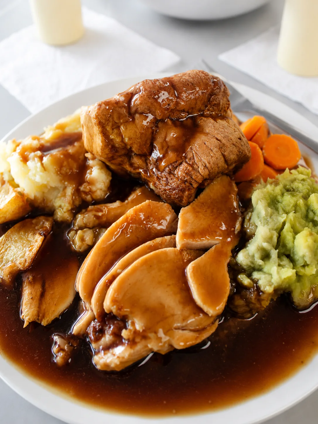Sunday dinner with roast meat, potatoes, carrots, peas and gravy